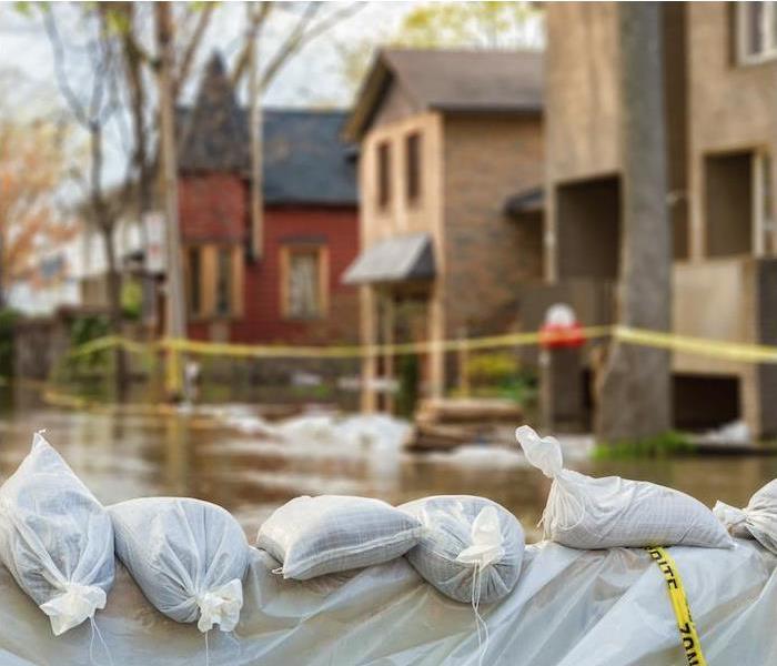  img src =”flood” alt = " bags of trash lined up along the street as clean up happens in the nearby homes after a flood ” >
